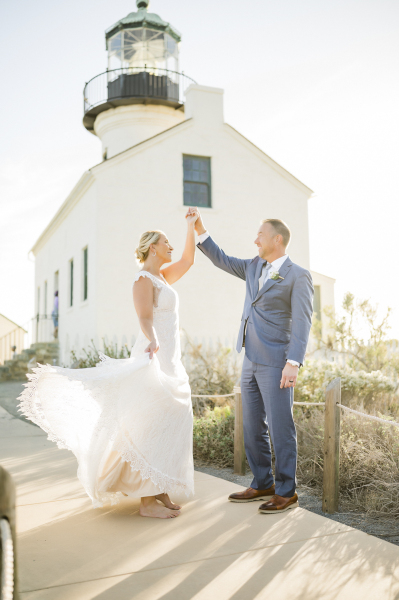 Bride dancing with groom in front of Point Loma lighthouse.
