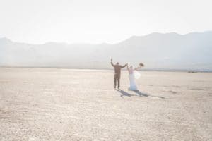 Newlywed couple celebrating in dry lake bed in Las Vegas.